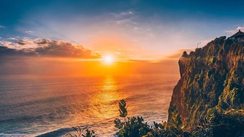 断崖にそびえたつウルワツ寺院と夕日