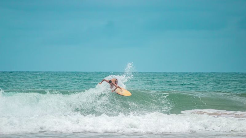 クタビーチでサーフィンを楽しむ旅行者の風景