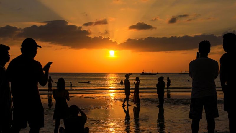 クタビーチの夕日に集まる人々