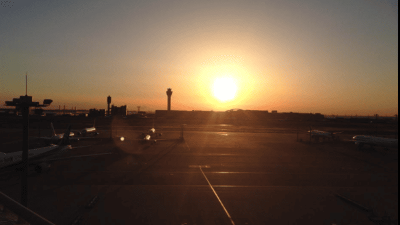 夜明けの羽田空港に朝日が昇り始める