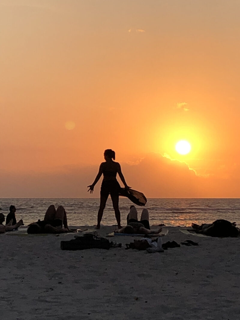 夕日の砂浜でヨガ